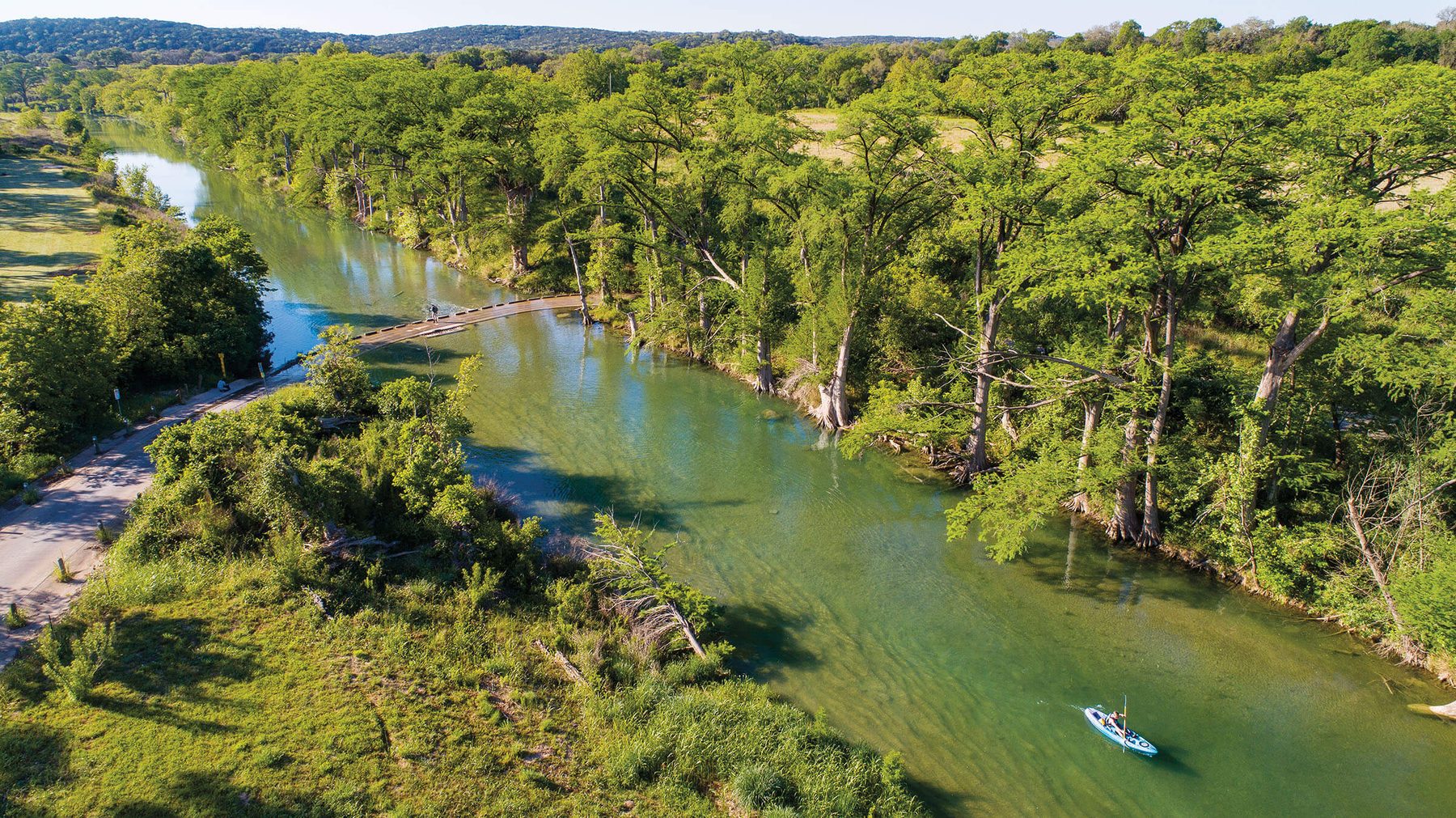 A cypress-lined bend of the Blanco River, showing a fully established native riparian canopy