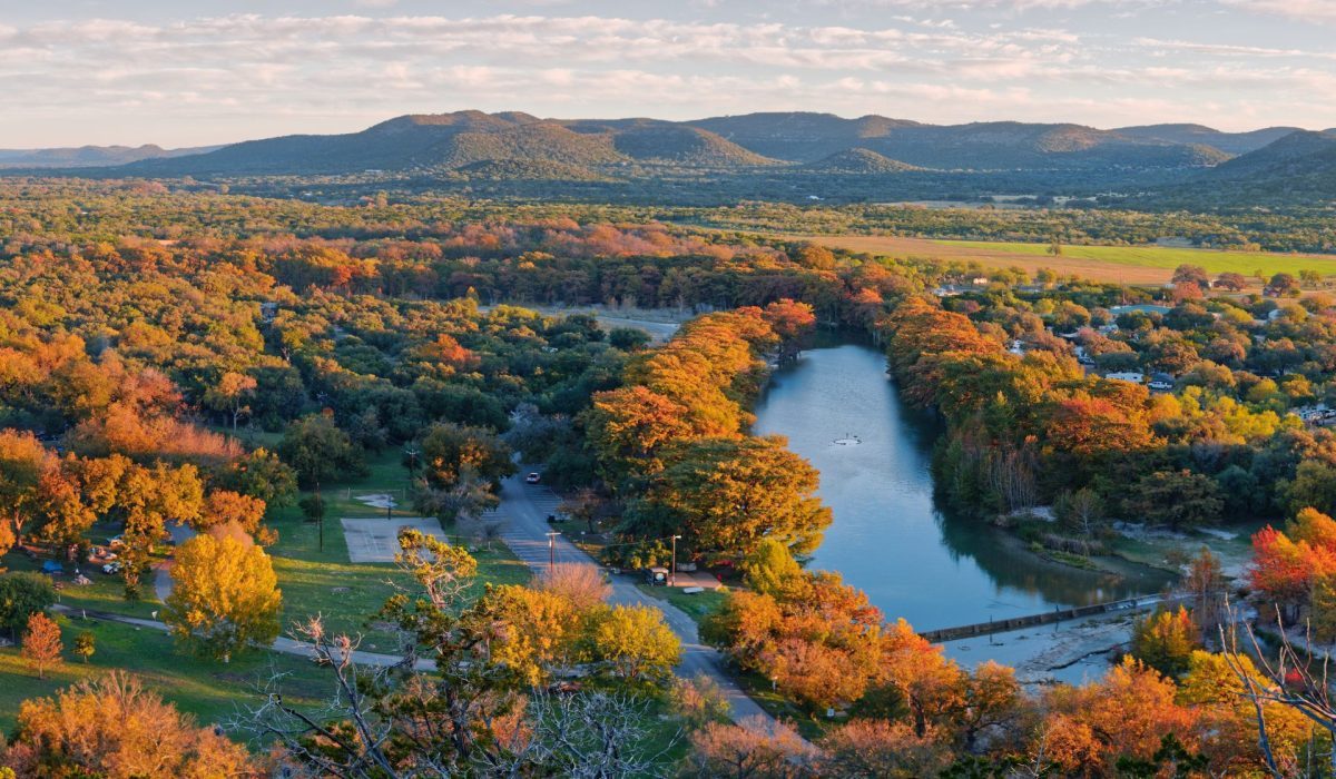 Aerial view of a tree-lined Hill Country waterway winding through the landscape